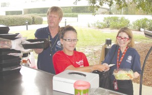 FEMA employees temporarily headquartered at Blythewood’s CSC building order lunch from Scottie’s Café food truck, one of several Blythewood businesses enjoying a boon in business while FEMA is in town. FEMA employees Paul Peterson of Connecticut, left, and Marcie Roth of Washington, D.C., purchase lunch from Scottie’s server Melissa Letrick. (Photo/Barbara Ball)
